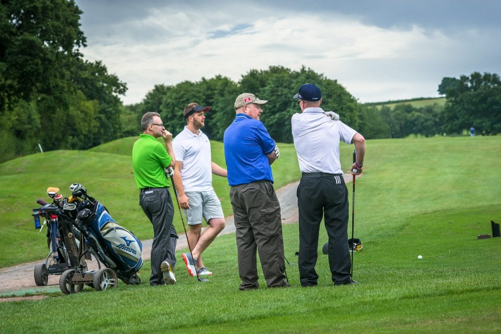 Group of four golfers waiting to tee off at The Shropshire Golf Club, enjoying a golf day on the championship golf course in Telford