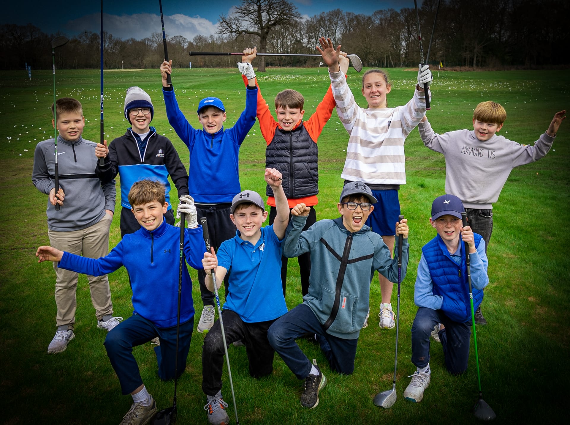 Junior golfers smiling at the camera after a group golf lesson at The Shropshire Golf Club in Telford, part of junior golf coaching in Telford
