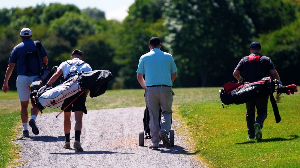 Four golfers walking together toward the next hole on the 18 hole golf course in Telford at The Shropshire Golf Club during a golf day