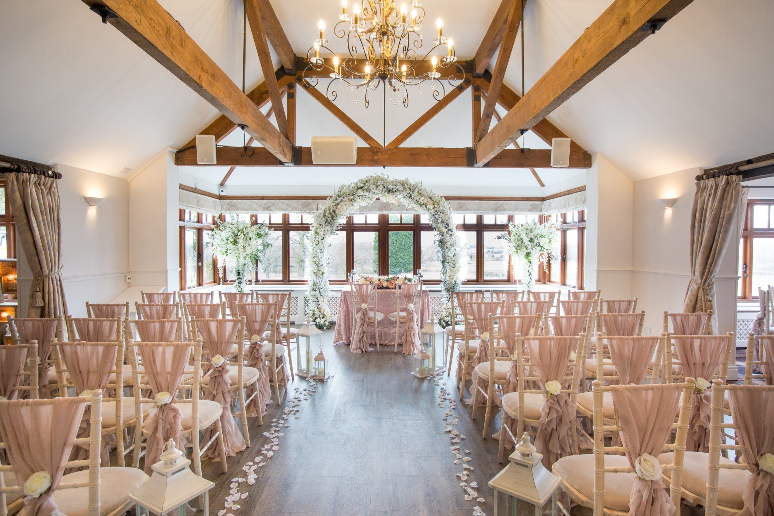 Rustic wedding venue Shropshire with pink chairs lining an old farmhouse aisle, perfect for wedding ceremonies at The Shropshire