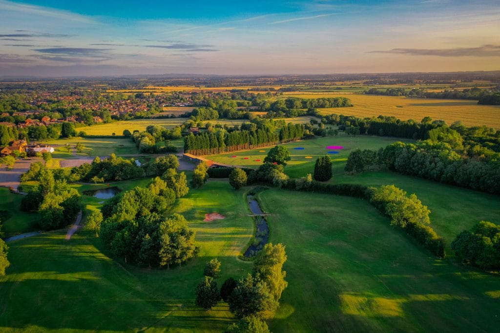 Aerial view of the entire 18 hole golf course in Telford at The Shropshire Golf Club, showcasing the full layout and surrounding natural landscape