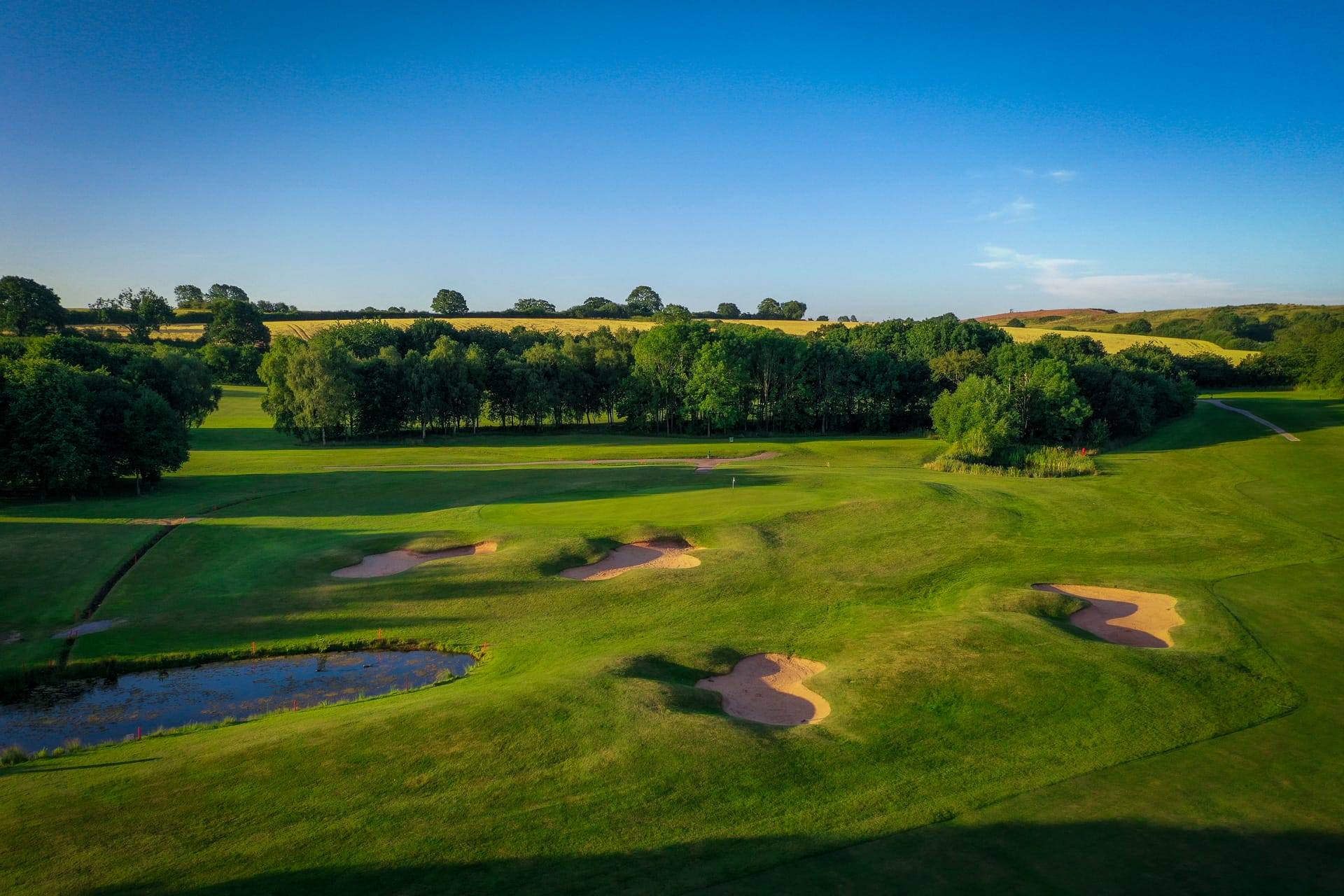 Scenic 18 hole golf course Shropshire featuring a challenging golf hole with water hazards, sand bunkers