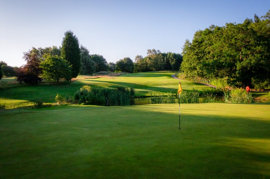 Golf green with flag on the 18 hole golf course in Telford at The Shropshire Golf Club