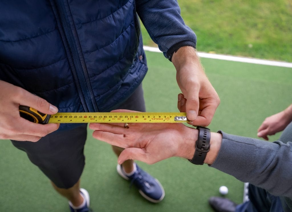 Golf coach measuring hand position during a golf lesson at The Shropshire Golf Club in Telford, part of individual golf coaching and golf lessons in Telford