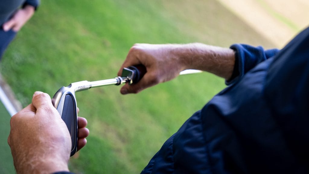 Golf professional adjusting the shaft of a club during a fitting session at The Shropshire Golf Club pro shop in Telford, offering expert golf club fitting and equipment services