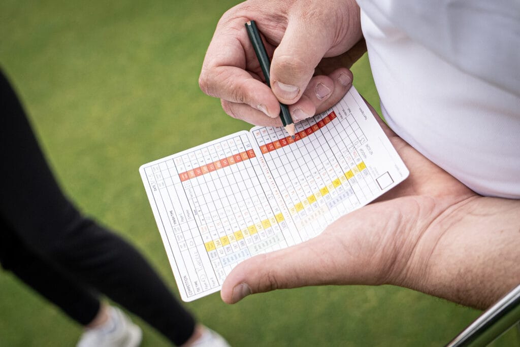 Golfer writing on a scorecard at The Shropshire Golf Club in Telford during a golf day on the 18 hole golf course